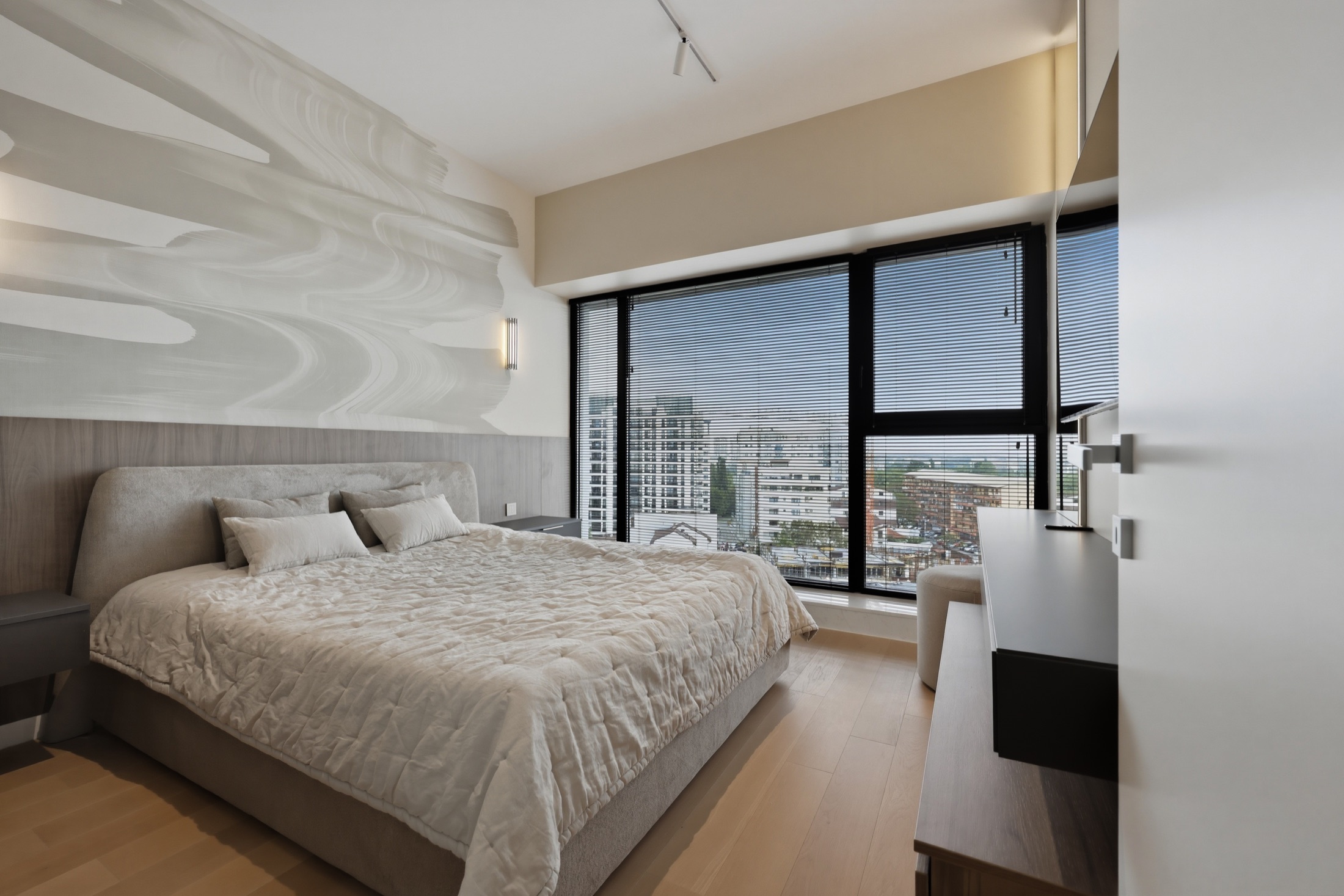 Primary bedroom with feature wall and full-height windows
